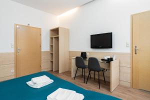 Habitación con escritorio, 2 sillas y TV. en Matejki-Kawowy en Poznan