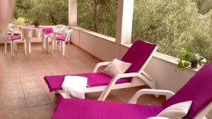 a balcony with purple and white chairs and a table at Holiday Home Oliveta in Brela