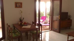 a dining room with a table and chairs and a television at Holiday Home Oliveta in Brela