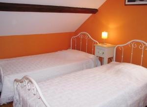 2 Betten in einem Zimmer mit orangefarbenen Wänden in der Unterkunft Casa bianca 