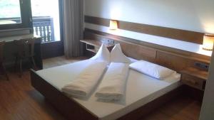 a bed with three pillows on it in a room at Ahrntalerhof in Campo Tures