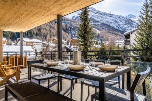 a table on a balcony with a view of a mountain at Riverside 2nd Floor South in Saas-Fee