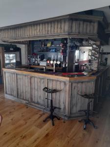 a wooden bar with two stools in a room at The George and Dragon Inn in Knighton