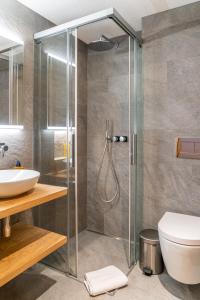 a bathroom with a shower and a toilet and a sink at Riverside 2nd Floor South in Saas-Fee