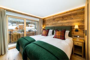a bedroom with two beds and a large window at Riverside 2nd Floor South in Saas-Fee