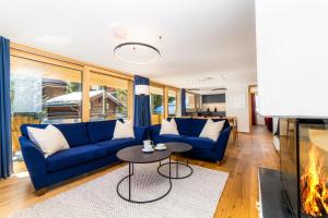 a living room with blue couches and a fireplace at Riverside 2nd Floor South in Saas-Fee