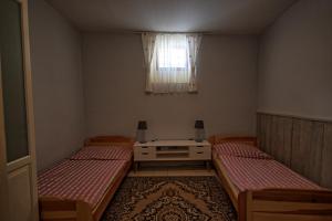 Habitación pequeña con 2 camas y ventana en Hostel Skautský dom en Banská Štiavnica