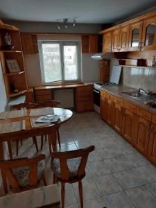 a kitchen with wooden cabinets and a table and chairs at Apartament in Cluj-Napoca