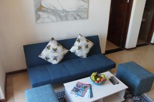 Wharf Side Inn في جزيرة بمبا: أريكة زرقاء مع الوسائد وطاولة في غرفة المعيشة
