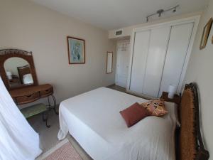 een slaapkamer met een wit bed en een spiegel bij Apartamento Cala y Mar in Alicante