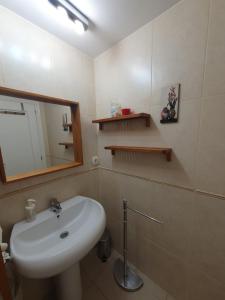 een badkamer met een wastafel en een spiegel bij Apartamento Cala y Mar in Alicante