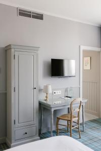a bedroom with a desk and a chair and a tv at La Maison d’Hôtes in Silly