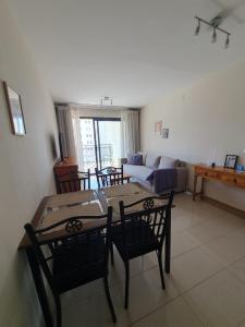 een woonkamer met een tafel en stoelen en een bank bij Apartamento Cala y Mar in Alicante