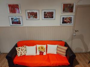 an orange couch with pillows and a vase of flowers on it at Appartamento Alba Gradoli in Gradoli