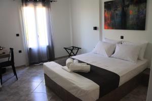 a bedroom with a large bed with a window at Petteo Serifos in Livadakia