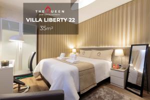 een hotelkamer met een groot wit bed en een spiegel bij The Queen Luxury Apartments - Villa Liberty in Luxemburg