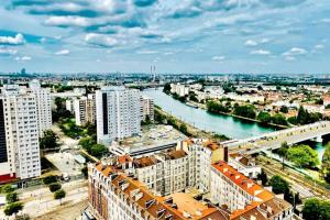 ein Blick auf eine Stadt mit einem Fluss und Gebäuden in der Unterkunft Ciel de Paris : Vue Tour Eiffel in Choisy-le-Roi