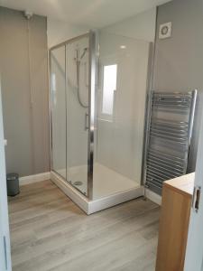 um chuveiro de vidro num quarto com piso de madeira em Valley Stream Guest Accommodation em Moira