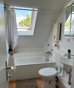 y baño con bañera, aseo y lavamanos. en Kölner Pension Apartments, en Colonia