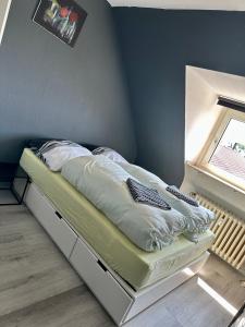 a bed in a room next to a window at Kölner Pension Apartments in Cologne