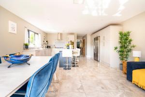 a kitchen and living room with a long table and blue chairs at Park House - FOUR star luxury with parking and WI-FI in Belfast