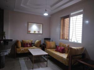 - un salon avec deux canapés et une fenêtre dans l'établissement Golden Beach, à Dar Hamida