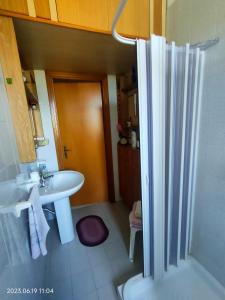 ein Badezimmer mit einem weißen Waschbecken und einer Dusche in der Unterkunft New Panoramic Apartment in Noto