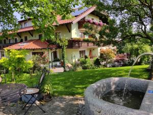 a garden with a fountain in front of a house at Pension Holzapfel in Sankt Georgen im Attergau