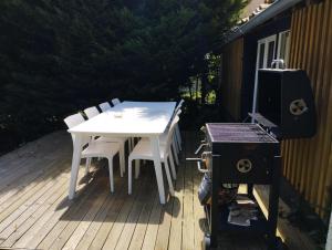 een witte tafel en stoelen op een terras met een grill bij Guest house aux portes du Bassin d'Arcachon in Mios