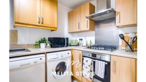 a kitchen with a stove and a dishwasher at Spacious 2 bedroom apartment with gated parking in Solihull
