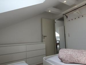 a white bedroom with a bed and a mirror at ruhige und moderne 2-Zi. Wohnung in Külsheim