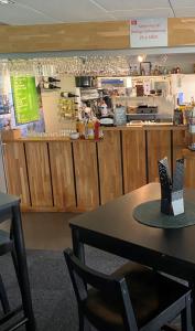 a restaurant with a table in front of a counter at Bedinge Golfklubb hotell in Beddinge Strand