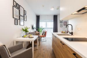 a kitchen with a sink and a table in a room at Apartamenty Jaworska 4 Wrocław in Wrocław