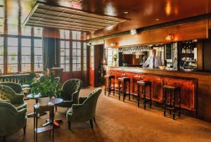 a bar at a restaurant with a man behind the counter at Absolue Renaissance in Magny-Cours