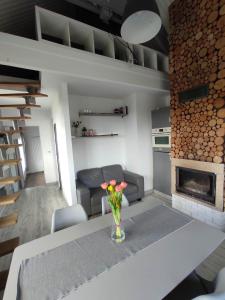 a living room with a table with a vase of flowers at Domek na Gorczańskiej in Rabka