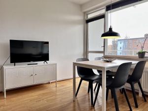 a dining room with a table with chairs and a television at Studio Apartment In Herlev, Herlevgrdsvej 2, 4 in Herlev