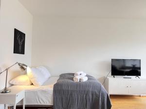 a white bedroom with a bed and a tv at Studio Apartment In Herlev, Herlevgrdsvej 2, 4 in Herlev