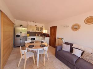 een keuken en een woonkamer met een tafel en een bank bij Bel appartement rénové, avec terrasse et piscine in La Croix-Valmer