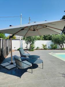 zwei Stühle und ein Regenschirm auf einer Terrasse in der Unterkunft Sweet Sicily Apartments in Carini