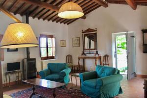 un soggiorno con tavolo e sedie blu di Il Borgo di Berentano a San Casciano in Val di Pesa