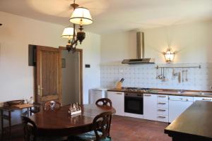 una cucina con tavolo in legno e una sala da pranzo di Il Borgo di Berentano a San Casciano in Val di Pesa