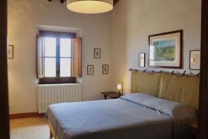 una camera con letto e finestra di Il Borgo di Berentano a San Casciano in Val di Pesa