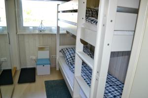 a bunk bed room with two bunk beds and a window at Modernes Ferienhaus direkt an der Nordsee in Wesselburenerkoog