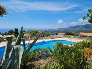 a villa with a swimming pool with mountains in the background at Bel appartement rénové, avec terrasse et piscine in La Croix-Valmer