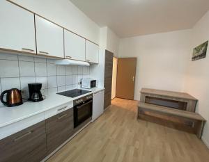 a kitchen with white cabinets and a wooden floor at Gelsenkirchen, 2-Zimmer Wohnung , 6 Person in Gelsenkirchen