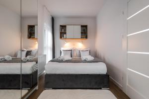 um pequeno quarto com 2 camas e um espelho em Apartamenty Jaworska 4 Wrocław - MAMY WOLNE POKOJE ! em Breslávia