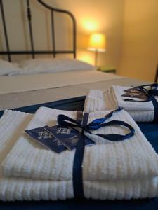 2 serviettes pliées avec un ruban bleu sur un lit dans l'établissement "RUNFULÌA" DELUX apartment, à Palerme