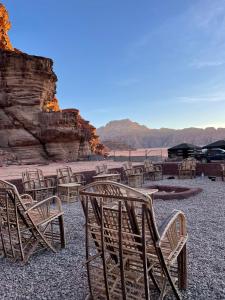 a group of chairs and tables on a beach at Adam Bedouin camp in Wadi Rum