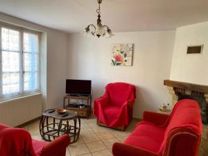ein Wohnzimmer mit 2 roten Stühlen und einem TV in der Unterkunft Melabelle in Malandry