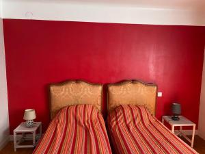 - un mur rouge avec 2 lits dans une chambre dans l'établissement Melabelle, à Malandry
